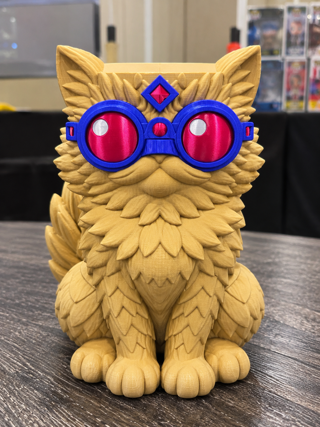 Hand-painted Princess Donut candle holder with golden fur, blue goggles, and pink lenses on a tabletop.