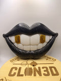 Black smiling lips wall artwork with white teeth and gold glitter tooth accents
