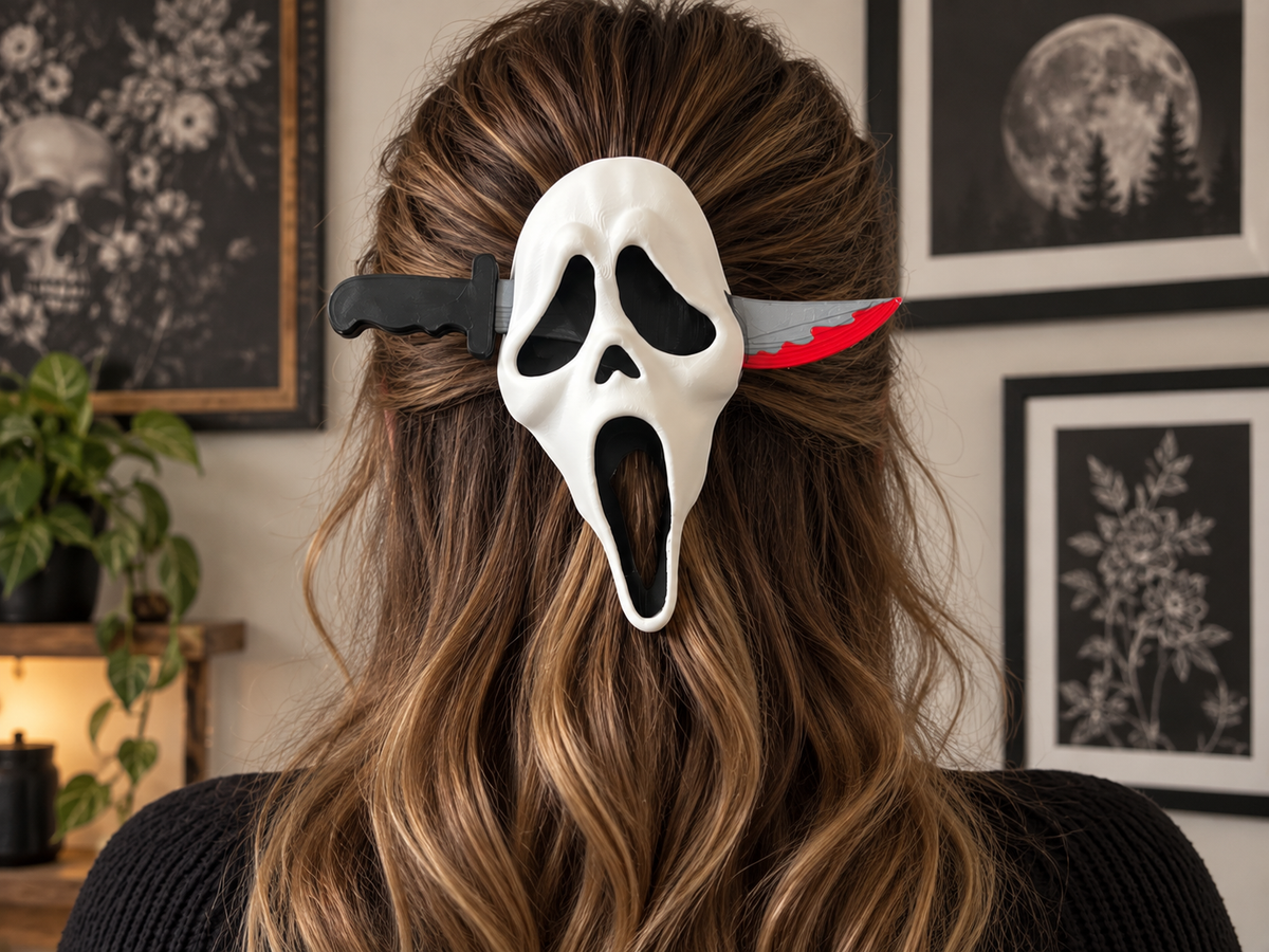 Ghost Face hair pin with a white screaming mask and decorative knife-shaped pin worn in a half-up hairstyle.