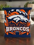 Denver Broncos candle holder in navy, orange, and white with horse-head emblem, mountain skyline, and raised top tray.