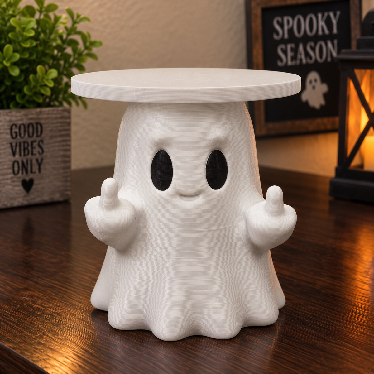 White ghost candle holder with black eyes, two raised middle fingers, and a circular top tray.