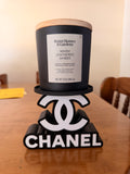 Black-and-white Chanel candle holder with a double-C motif and lettering base; wax candle pictured, but holder is for flameless LED candles only.