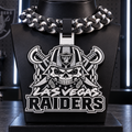 Black-and-white Las Vegas Raiders hype chain with a helmeted skull, crossed blades, and Raiders lettering on a black display bust.