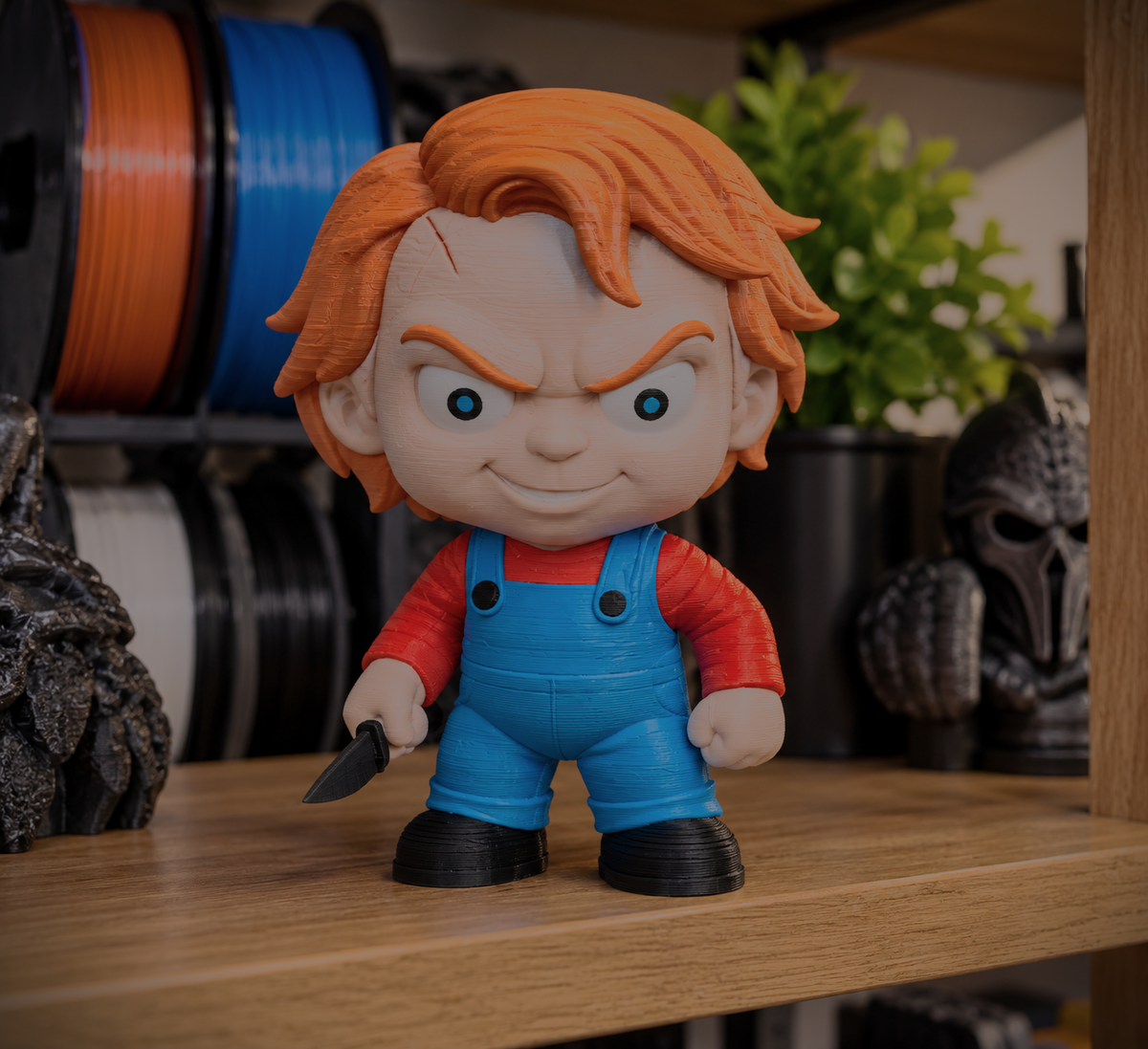 Finished Chucky micro statue with orange hair, blue overalls, and a red shirt, shown as a preview for the digital 3MF download.