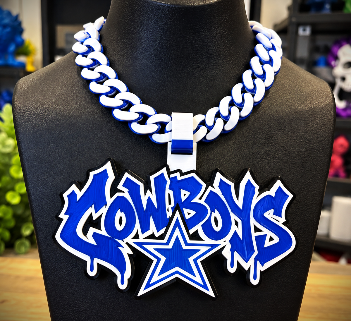Dallas Cowboys Graffiti hype chain with blue-and-white lettering and a star beneath on a black display bust.