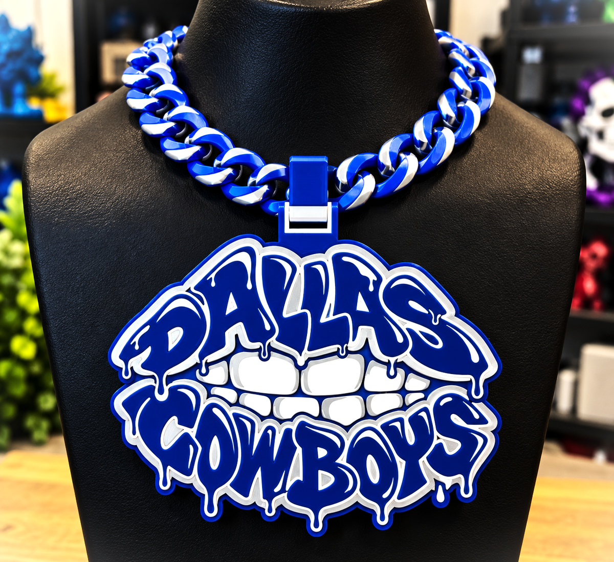 Blue-and-white Dallas Cowboys Lip hype chain with teeth and dripping graffiti-style lettering on a black display bust.