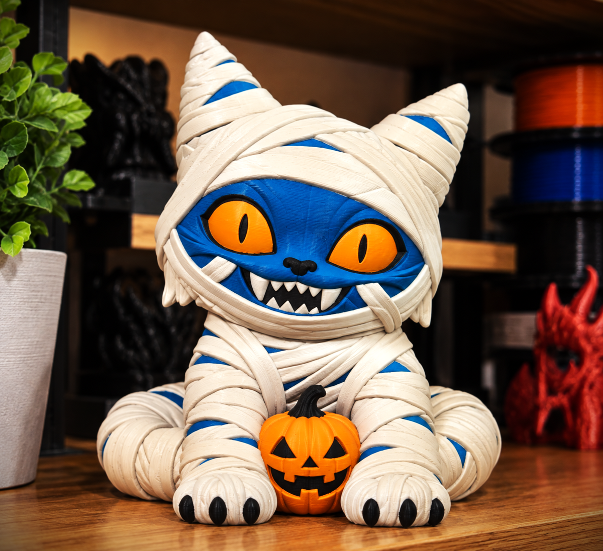 Blue Derpy Cat statue wrapped in mummy-style bandages with orange eyes and a pumpkin, shown as a preview for the digital 3MF download.