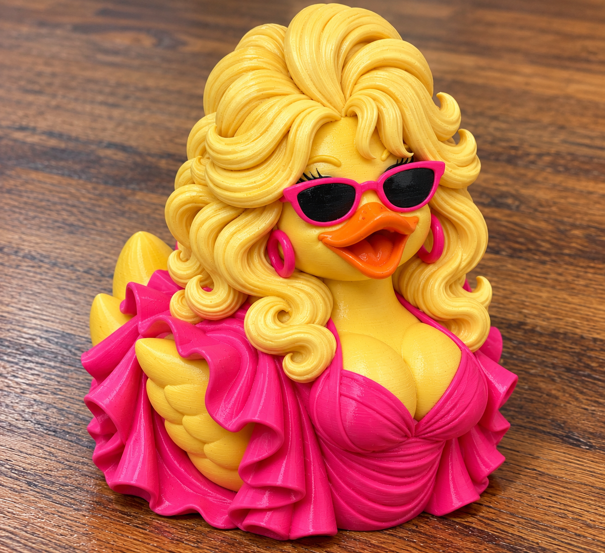 Dolly Parton Duck figurine with blonde curls, pink sunglasses, hoop earrings, and a bright pink ruffled outfit.