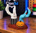 Jack and Sally candle holder with skeletal and blue stitched hands beside an orange jack-o'-lantern on a textured base.