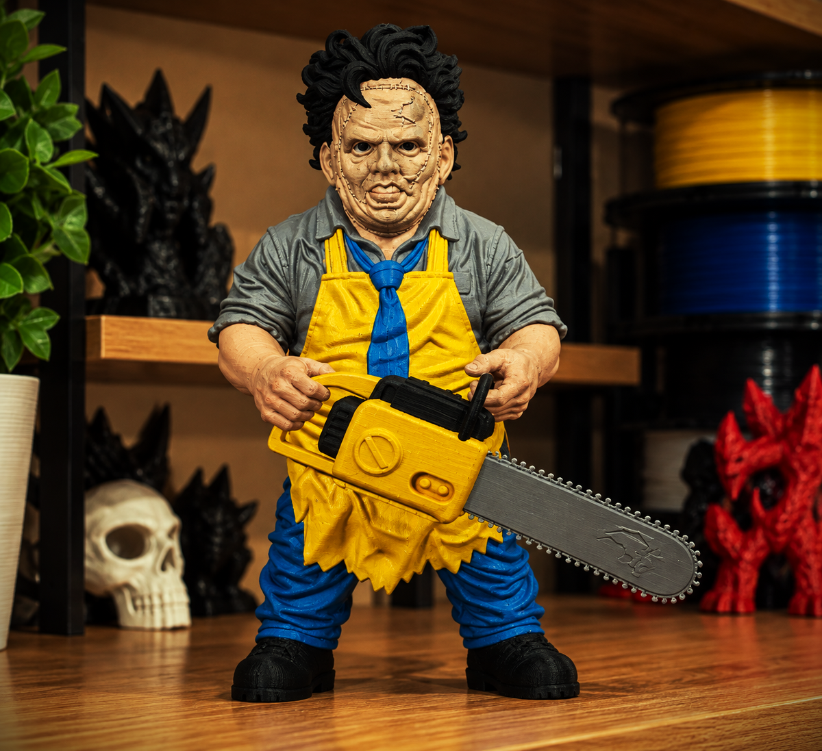 Leatherface micro statue with stitched mask, yellow apron, and chainsaw, shown as a preview for the digital 3MF download.